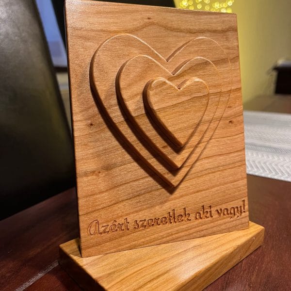 Azért szeretlek aki vagy feliratú cseresznyefából készült 3D vágási technikájú asztaldísz ahol a szívek a szerelmet szimbolizálják.